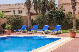 a group of blue lounge chairs next to a swimming pool at Spacious 3 bed 2 bath villa with Garden and Pool in Mirleft