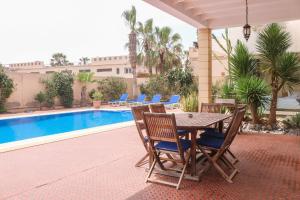 a patio with a table and chairs next to a pool at Spacious 3 bed 2 bath villa with Garden and Pool in Mirleft