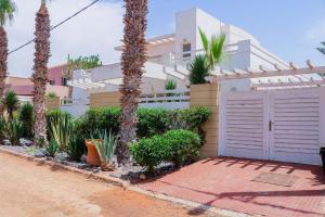 a house with palm trees and a white fence at Spacious 3 bed 2 bath villa with Garden and Pool in Mirleft +80 photos