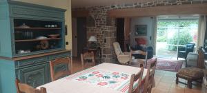 a dining room with a table and a living room at Gîtes Pour Tous in Dragey