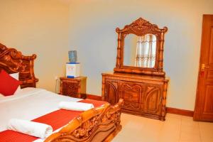a bedroom with a bed and a large mirror at Homebase gardens guesthouse in Nakuru