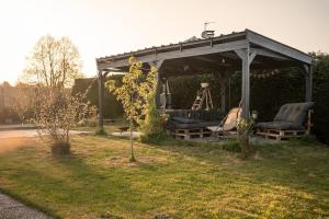 a gazebo with chairs under it in a yard at La bohème Langogne in Langogne