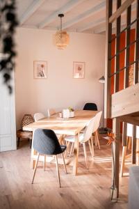 a dining room with a wooden table and chairs at La bohème Langogne in Langogne