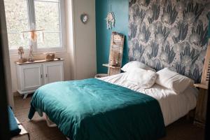 a bedroom with a bed with a turquoise blanket at La bohème Langogne in Langogne