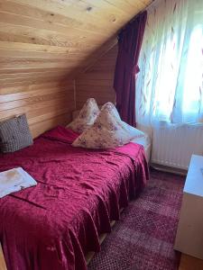 a bedroom with a bed with a red comforter at Pensiunea Alexa in Durău +23 photos