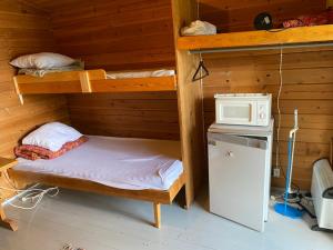 a room with two bunk beds and a microwave at Pirttiniemen Lomakylä in Muurasjärvi