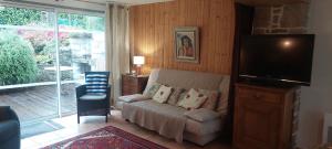 a living room with a couch and a flat screen tv at Gîtes Pour Tous in Dragey