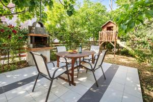 a patio with a table and chairs and a grill at Andronis in Potos