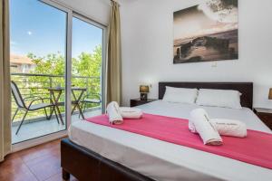 a bedroom with a large bed and a balcony at Andronis in Potos