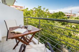 a balcony with a wooden table and a book at Andronis in Potos