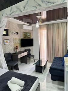 a bedroom with a bed and a desk and a couch at Hotel City Building2 in Zugdidi