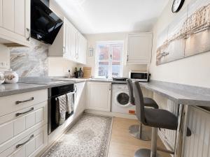 a kitchen with white cabinets and a washer and dryer at 2 Bedroom Flat in Manchester