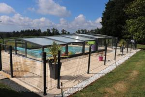 a pavilion with a pool in the background at Gîte Ty Traon piscine partagée in Ergué-Gabéric