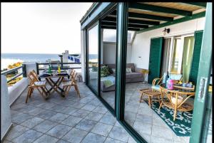 a patio with a table and chairs on a balcony at Aegean Verde Retreat in Sounio