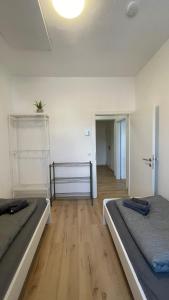 two beds in a room with a wooden floor at Großes Monteurhaus Großharras in Großharras