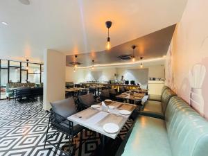 ein Restaurant mit Tischen und Stühlen in einem Raum in der Unterkunft Hotel Kyzen - Hitec city, Hyderabad in Hyderabad