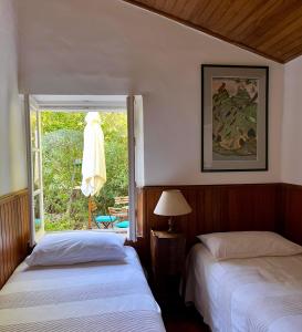 a bedroom with two beds and a window with a chair at Le Manoir de Port-Cros in Port-Cros +121 photos