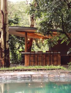 a pavilion with a pool in front of a house at the Roost Tented Camp in Arusha