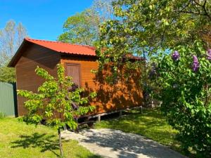 a small house with a red roof in a yard at Nika's house in Mtskheta