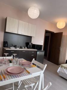 a kitchen with a table and chairs and a kitchen with a table and chairsktop at Корал in Obzor