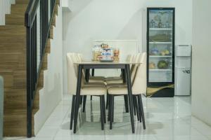 a dining room table with chairs and a refrigerator at TWD hostel in Malang