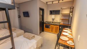 a small room with two bunk beds and a kitchen at Ap Passarela in Porto Seguro