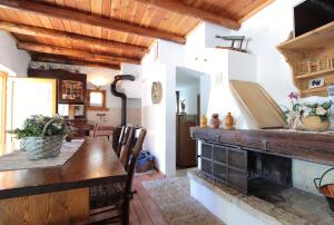 a kitchen with a wooden table and a fireplace at Baita Costa Di Gial in Lamon