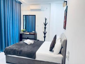 a bedroom with a large bed with blue curtains at COCO Rooms in Galle