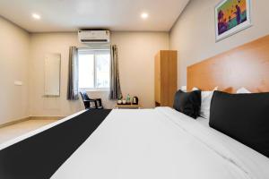 a bedroom with a large bed and a window at Super Collection O RBS ECIL in Hyderabad +43 photos