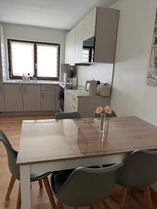 a kitchen with a wooden table with chairs and a dining room at SleepHaven in Walldürn