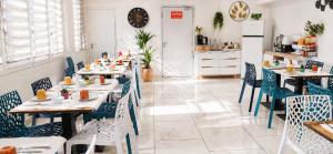 a restaurant with tables and chairs and a kitchen at Hôtel Duchesse Anne in Lourdes