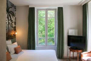 a hotel room with a bed and a window at Le Palace de Menthon in Menthon-Saint-Bernard