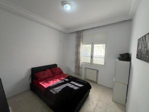 a bedroom with a bed in a white room at La Marsa in El Aouina Station