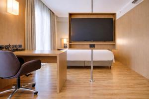 a hotel room with a bed and a desk and a television at Quality Hotel & Suites Brasília in Brasília