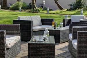 a group of wicker chairs and tables on a patio at Best Western Bolholt Country Park Hotel in Bury