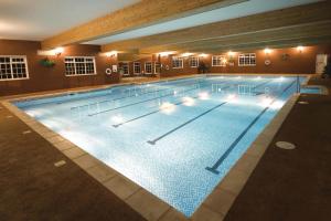 a large swimming pool with lights on it at Best Western Bolholt Country Park Hotel in Bury