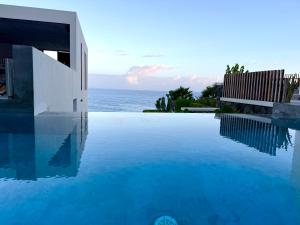 a swimming pool with a view of the ocean at Walhalla Seahouse in Chã da Igreja