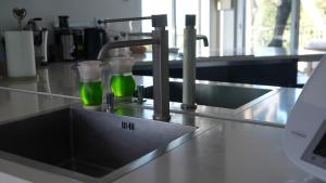 a kitchen counter with a sink with green liquid at Villa Azur Horizon in La Turbie