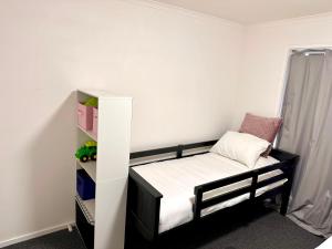 a small bedroom with a bed and a shelf at Sunny Shackell - family and pet friendly in Echuca
