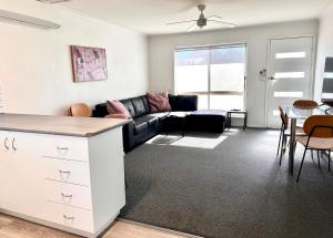 a living room with a couch and a table at Sunny Shackell - family and pet friendly in Echuca