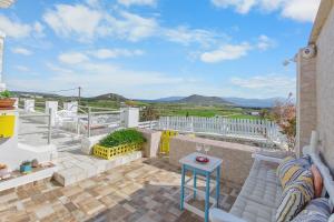 a patio with a table and chairs on a balcony at Antigone's Blue Vista in Kampos Paros
