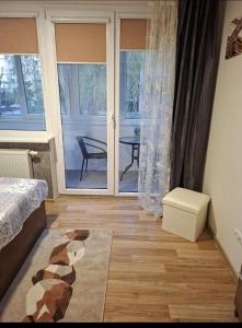 a bedroom with a bed and a sliding glass door at Amber Stay Birštonas in Birštonas