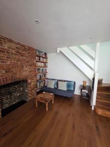 a living room with a couch and a brick wall at The Salty Loft in Hastings