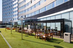 a restaurant with tables and chairs in front of a building at Alexandre Fira Congress in Hospitalet de Llobregat