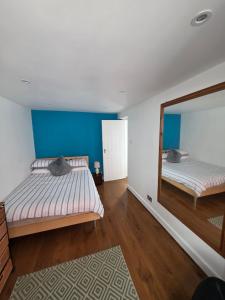a bedroom with two beds and a large mirror at The Salty Loft in Hastings