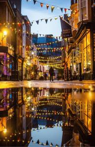 a city street with lights and a reflection in a puddle at The Salty Loft in Hastings