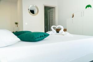 a white bed with green and white pillows on it at R & A Resident in Năvodari