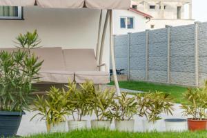 a chair under an umbrella on a patio with plants at R & A Resident in Năvodari