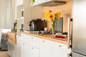 a kitchen with a vase of flowers on a counter at R & A Resident in Năvodari +20 photos