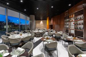 a restaurant with tables and chairs and windows at Alexandre Fira Congress in Hospitalet de Llobregat